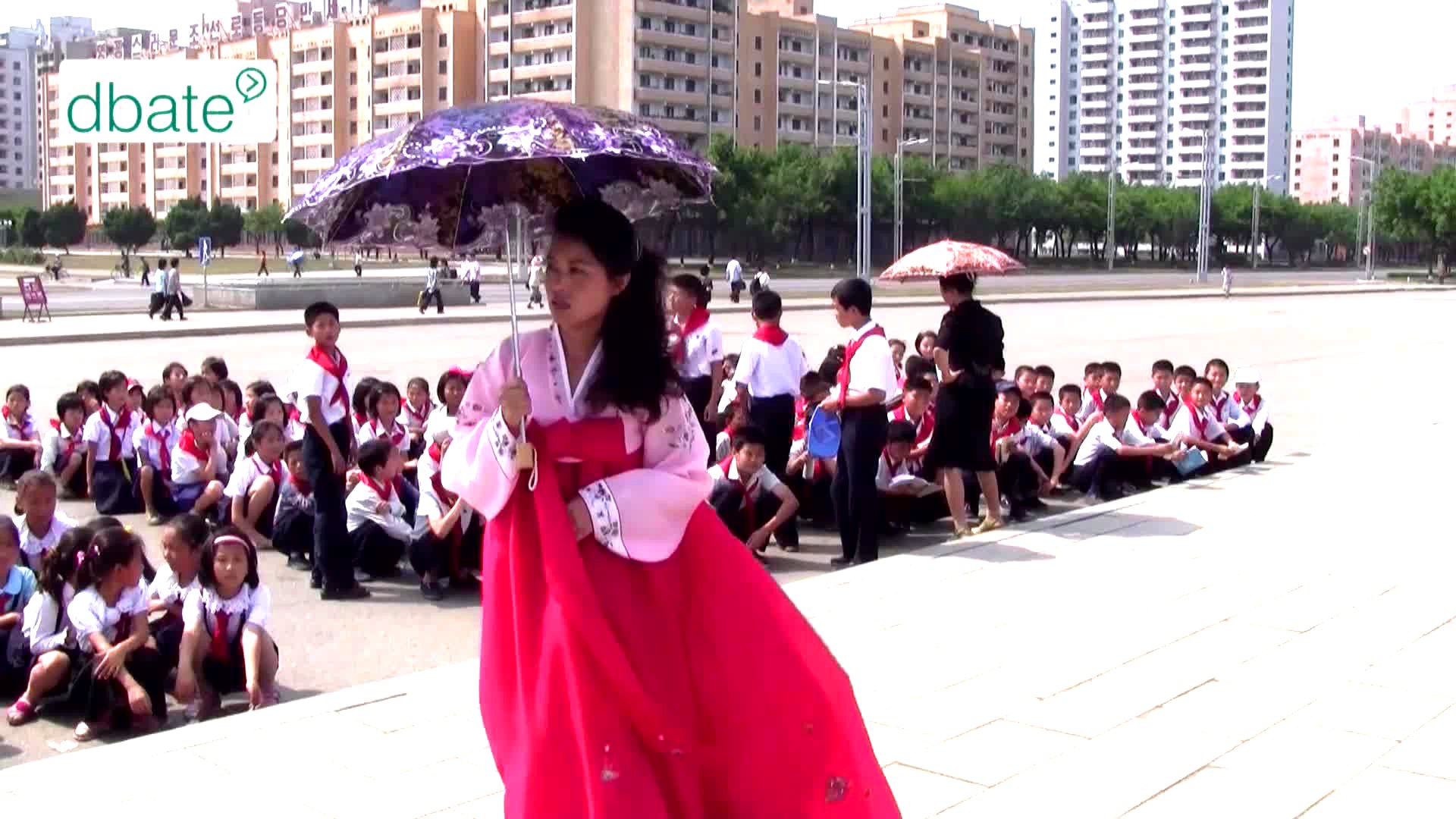 Eine junge Frau steht in Nordkorea auf einem Platz.