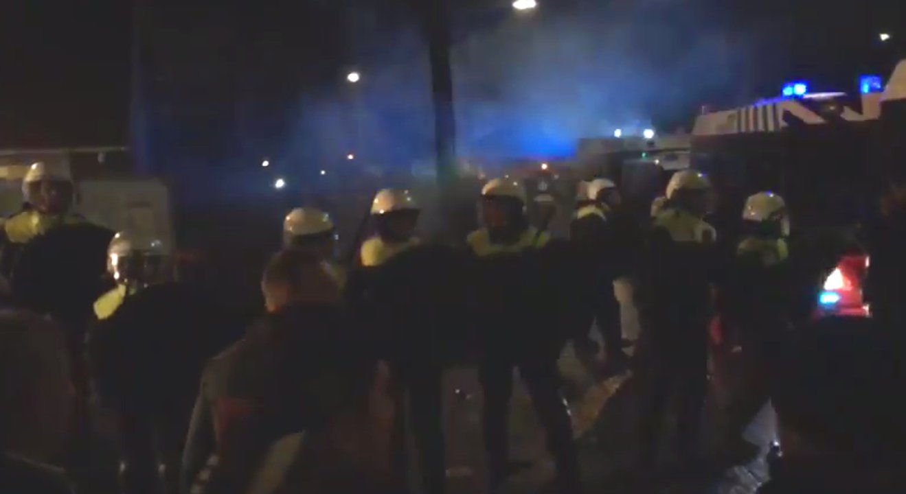 Holländische Polizisten stehen fremdenfeindlichen Demonstranten in Geldermalsen gegenüber