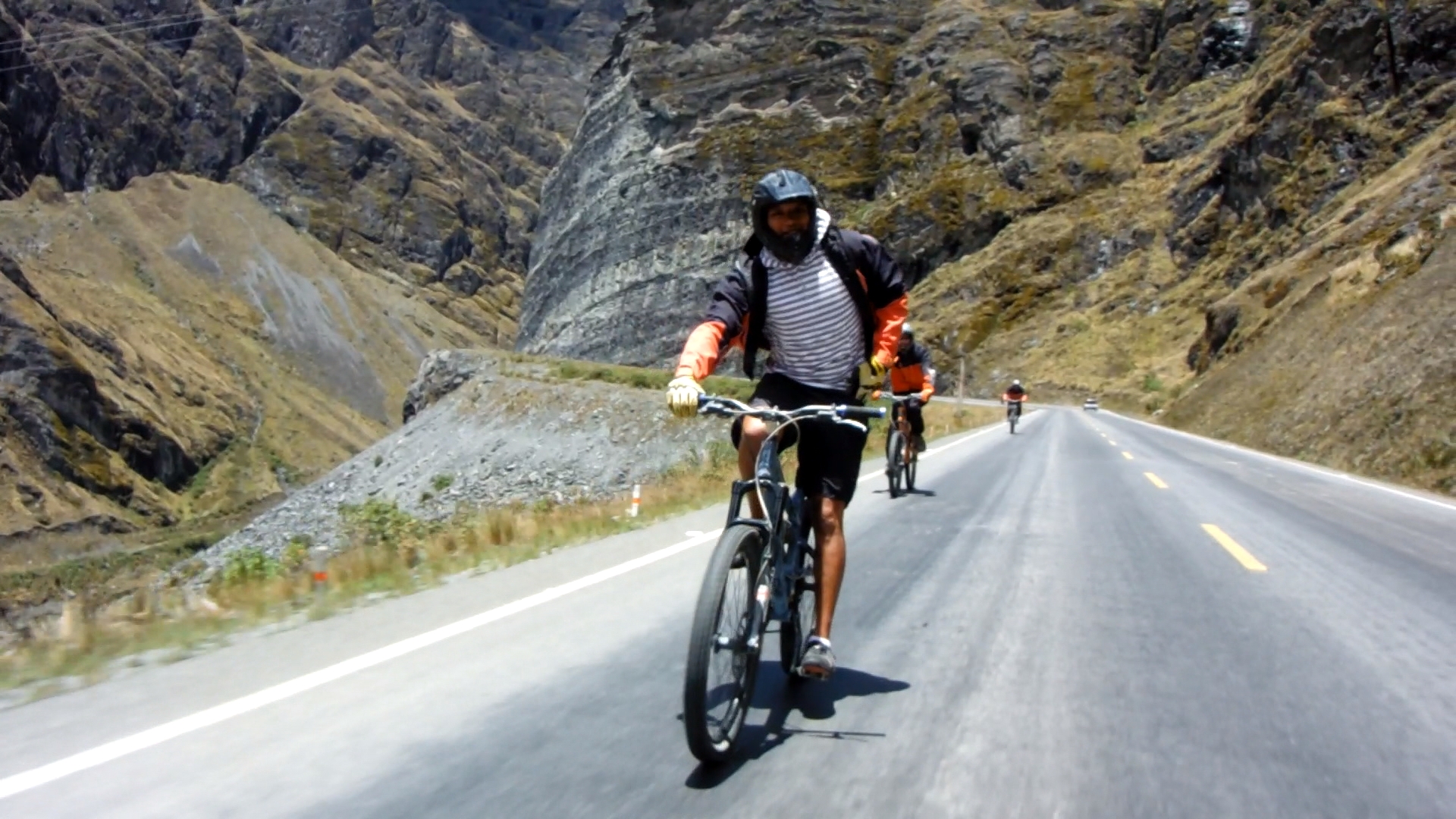 Videotagebuch Boliviens Todesstraße - Fahrt in den Abgrund: Radfahrer auf einer asphaltierten Straße auf dem Weg nach unten